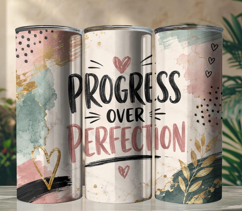 May include: Three cylindrical tumblers featuring a watercolor design in shades of pink, teal, and gold. The center tumbler displays the black text "PROGRESS OVER PERFECTION" with small heart icons, while the others show abstract brushstrokes, gold leaf accents, and black polka dots.