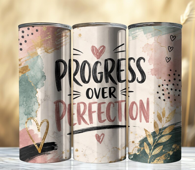 May include: Three cylindrical tumblers featuring a cream-colored marble background with abstract watercolor splashes in dusty pink, sage green, and black. The text "PROGRESS OVER PERFECTION" is printed in black and pink, accented by gold hearts and leaves.