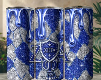 May include: A cylindrical tumbler featuring a blue and silver glitter diamond pattern with a blue liquid drip effect at the top. The center displays a blue shield emblem with the text ZETA PHI BETA and the year 1920, surrounded by white pearls.