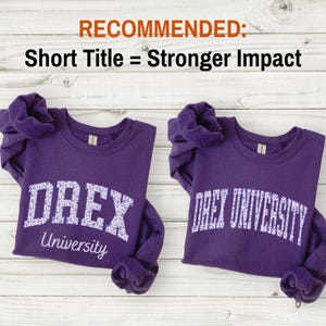 May include: Two purple crewneck sweatshirts featuring white patterned lettering. The left sweatshirt displays the text DREX University, while the right sweatshirt displays the text DREX UNIVERSITY. Both garments have long sleeves and ribbed collars.