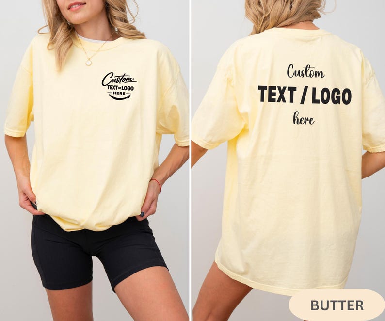 May include: A pale yellow t-shirt with the text "Custom TEXT/LOGO here" in black on the front and back. The shirt has a relaxed fit and short sleeves. The word "BUTTER" is at the bottom of the image.