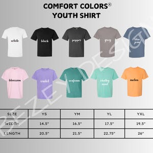 以下が含まれることがあります： 白、黒、ペッパー、グレー、ブルージーンズなど、さまざまな色のComfort Colorsユースシャツのディスプレイ。その他の色は、ブロッサム、バイオレット、シーフォーム、チョーキーミント、メロンです。画像には、インチ単位の寸法を含むサイズチャートも含まれています。