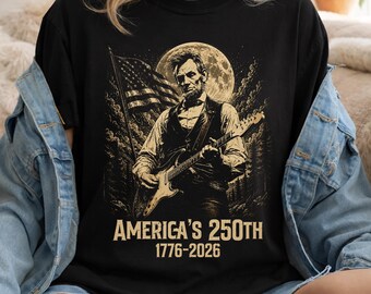 Maglietta con Abraham Lincoln che suona la chitarra verso la luna, Maglietta per il 250° anniversario dell'America, Maglietta patriottica con Lincoln e chitarra, Maglietta per il Giorno dell'Indipendenza USA 1776-2026