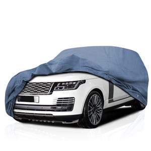 May include: A white SUV is partially covered by a blue car cover. The cover drapes over the hood and roof, obscuring the top half of the vehicle. The car has black wheels and a silver grill.