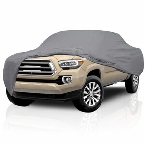 Peut inclure: Une housse de voiture grise recouvrant un pick-up beige. La housse épouse la forme du véhicule, couvrant le capot, le toit et la benne. Le camion a des roues noires et une calandre chromée.