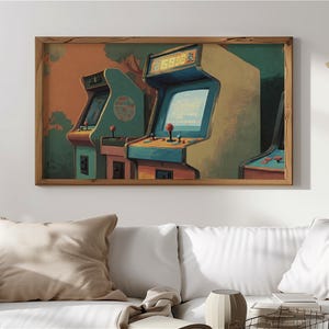Op de afbeelding: Een ingelijste print met drie vintage arcade-machines. De machines hebben een retro kleurenpalet van teal, beige en rood, tegen een oranje en groene achtergrond. Het kunstwerk roept nostalgie op voor klassiek gamen.