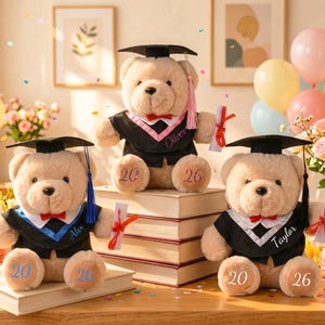 May include: Three teddy bears in graduation gowns and mortarboards, each holding a scroll. The bears have the numbers "20" and "26" on their paws. Names are embroidered on the gowns. The scene includes balloons, flowers, and books, celebrating graduation.