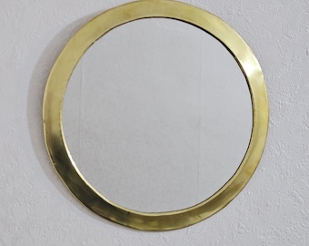 Peut inclure: Un miroir rond avec un cadre en métal doré. Le miroir reflète l'environnement. Le cadre a une finition lisse et polie. C'est un objet décoratif, idéal pour différents styles d'intérieur.