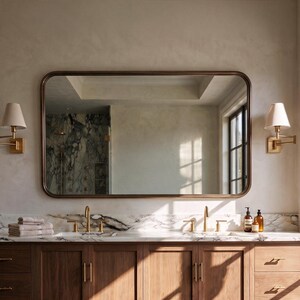 A burnished bronze wide horizontal wall mirror offering sophisticated warmth to a contemporary master bath decor.