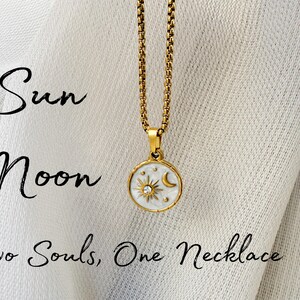 May include: A gold-toned chain necklace with a round pendant featuring a white enamel inlay, a sun and moon motif, and a small embedded crystal. The text "Sun Moon" and "Two Souls, One Necklace" is printed in black script on the left side of the image.