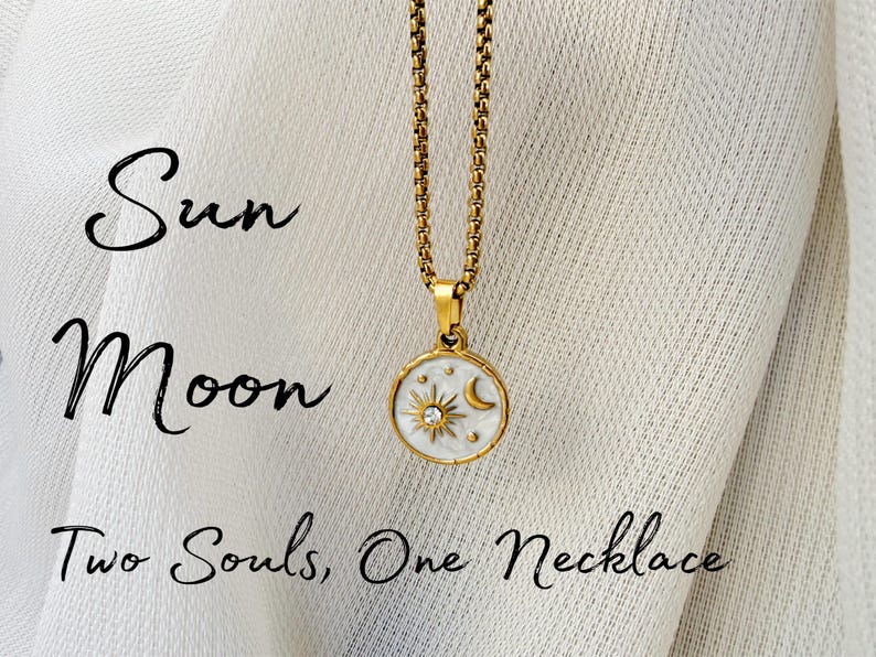 May include: A gold-toned chain necklace with a round pendant featuring a white enamel inlay, a sun and moon motif, and a small embedded crystal. The text "Sun Moon" and "Two Souls, One Necklace" is printed in black script on the left side of the image.