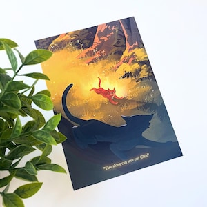 Pu&ograve; includere: Una stampa artistica rettangolare che mostra la sagoma scura di un gatto in primo piano e un gatto arancione brillante che corre attraverso una foresta soleggiata sullo sfondo. Il testo "Fire alone can save our Clan" &egrave; stampato in oro in basso.