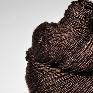 May include: A skein of brown yarn with a slightly textured surface.