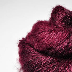 May include: A skein of deep burgundy yarn with a soft, fuzzy texture.