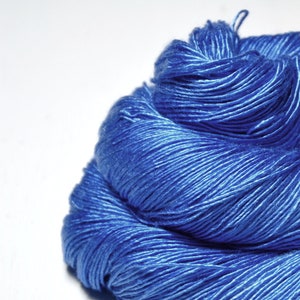 May include: A close-up of a skein of blue yarn. The yarn is soft and smooth, and it is perfect for knitting or crocheting.