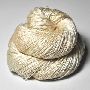 May include: A skein of cream-coloured silk yarn, ideal for knitting or crocheting fine projects.