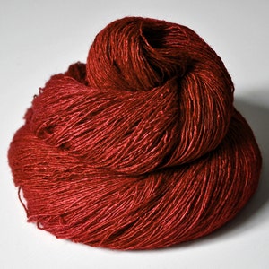 May include: A skein of deep red yarn, loosely wound and ready for knitting or crocheting.