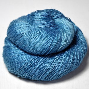 May include: A skein of blue yarn, wound into a ball shape. The yarn is a deep blue color with a slight sheen.