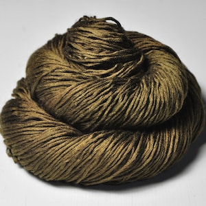 May include: A skein of olive green yarn, tightly wound and textured. The yarn appears to be a natural fiber, with variations in color and tone. The image is a close-up, highlighting the details of the yarn's construction. Ideal for knitting and crochet projects.