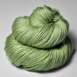 Puede incluir: Un ovillo de hilo suave y verde, perfecto para tejer o hacer ganchillo.