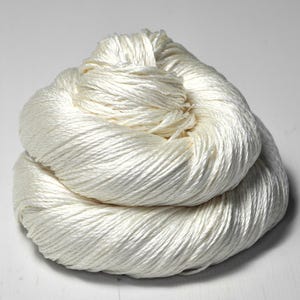 May include: A skein of white silk yarn, perfect for knitting or crocheting delicate projects.