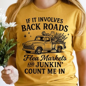 Puede incluir: Camiseta amarilla mostaza con un gráfico de una camioneta vintage cargada de muebles. El texto dice: "Si involucra caminos rurales, mercados de pulgas y cacharreo, cuenten conmigo."
