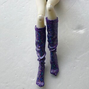 May include: A pair of purple sparkly knee-high boots with iridescent glitter.