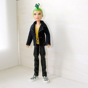 May include: A doll with green hair styled in a mohawk, wearing a black jacket with a yellow shirt underneath, black trousers, and black and white checkered shoes.
