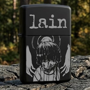 May include: A matte black metal lighter featuring the word lain in a stylized font at the top. Below the text is a grey graphic illustration of a person with short hair, a halo-like circle behind their head, and two hands reaching inward.