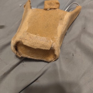 May include: A brown felt pouch with a white strap. The pouch is open and the inside is visible.