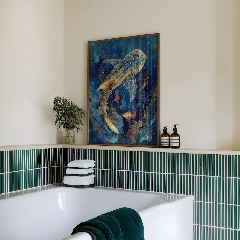 May include: A framed art print featuring a whale shark swimming in a deep blue ocean. The artwork has gold and white accents, with smaller fish and bubbles. The print is displayed above a white bathtub with a green tiled wall.