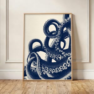 Pode incluir: Uma impressão de arte de parede retangular vertical com uma ilustração detalhada em tinta azul escura de vários tentáculos de polvo com ventosas visíveis, sobre um fundo branco sujo em uma moldura fina de madeira clara.