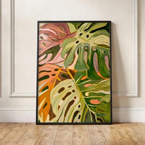 Könnte beinhalten: Ein rechteckiger gerahmter Wandkunstdruck mit einem stilisierten Gemälde von Monstera-Blättern. Das Kunstwerk zeigt eine lebendige Farbpalette aus tiefem Waldgrün, hellem Salbei, sanftem Pfirsich und leuchtendem Orange mit sichtbaren Pinselstrichen.