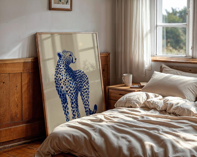May include: A large rectangular framed wall art print featuring a stylized illustration of a cheetah. The cheetah is rendered in shades of deep blue with a distinct spotted pattern against a solid, light beige background within a wooden frame.