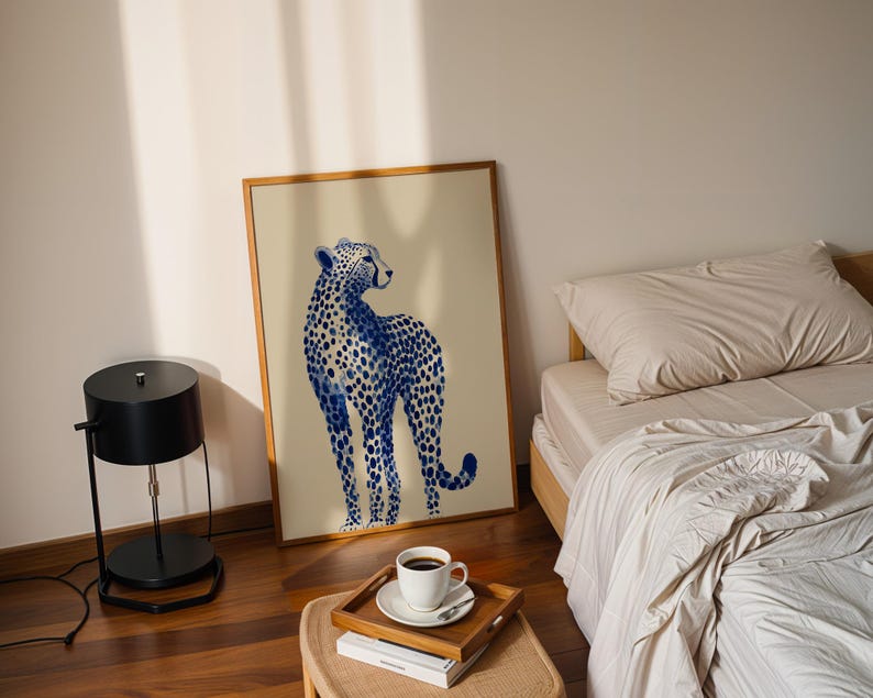 May include: A rectangular framed wall art print featuring a blue and white watercolor-style illustration of a standing cheetah. The cheetah is depicted in profile, facing right, with detailed blue spots against a light beige background.