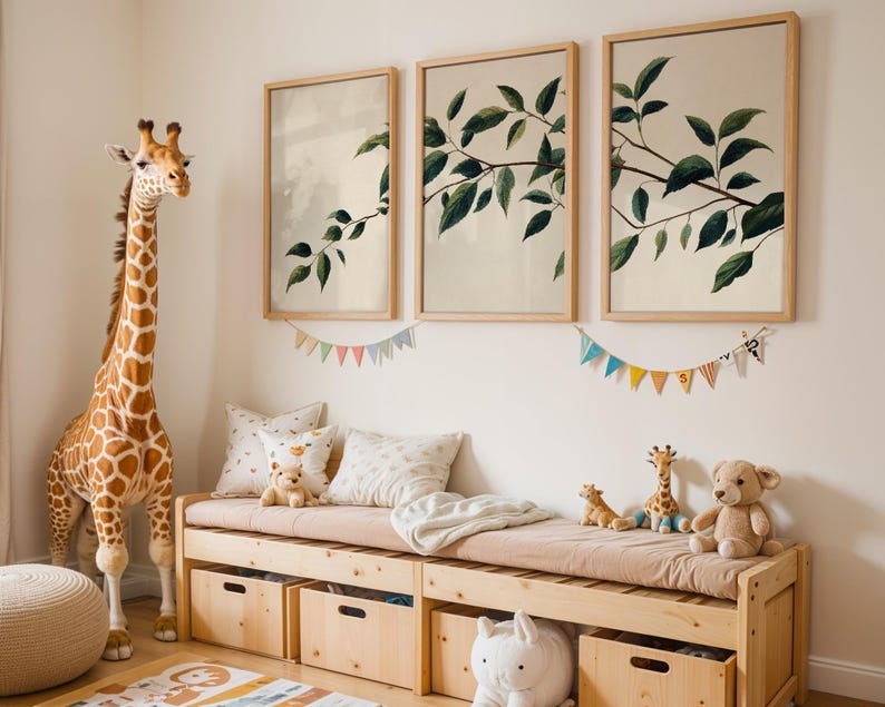 May include: A wooden storage bench with a beige cushion, four wooden storage bins, and three framed botanical prints featuring green leaves on a light background. A large plush giraffe stands beside the bench, with smaller plush toys on top.