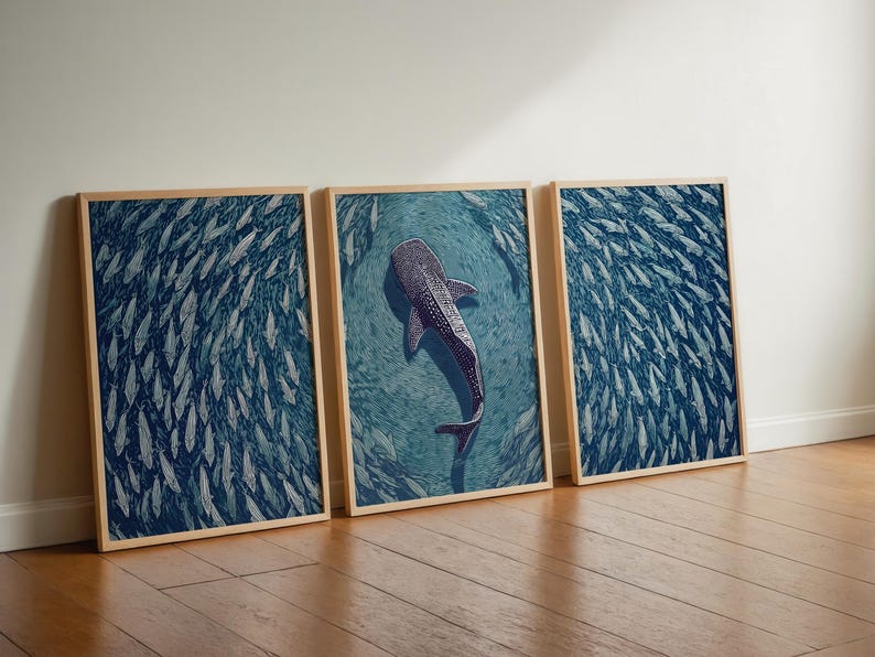 Pode incluir: Um conjunto de tr&ecirc;s quadros de parede emoldurados com uma paleta de cores azul profundo. As duas molduras externas exibem um denso cardume de peixes, enquanto a central retrata um grande tubar&atilde;o-baleia nadando entre peixes menores.