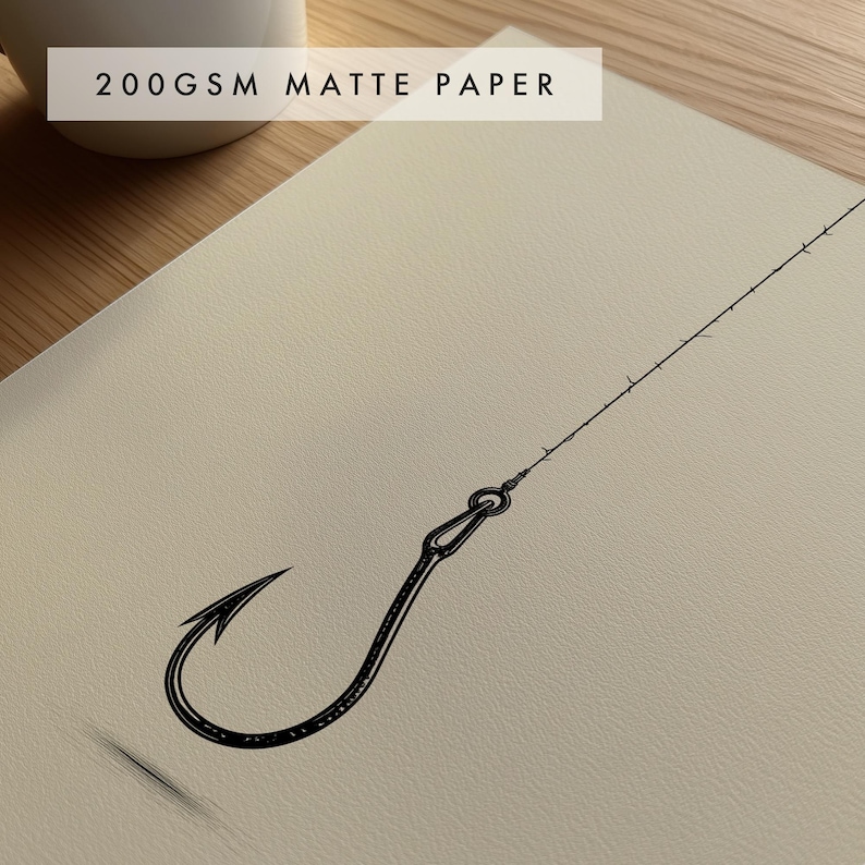 May include: A black ink line drawing of a single fishing hook attached to a thin line, printed on off-white 200gsm matte paper. The hook features a sharp barb and a looped eyelet, with the fishing line extending diagonally across the textured surface.