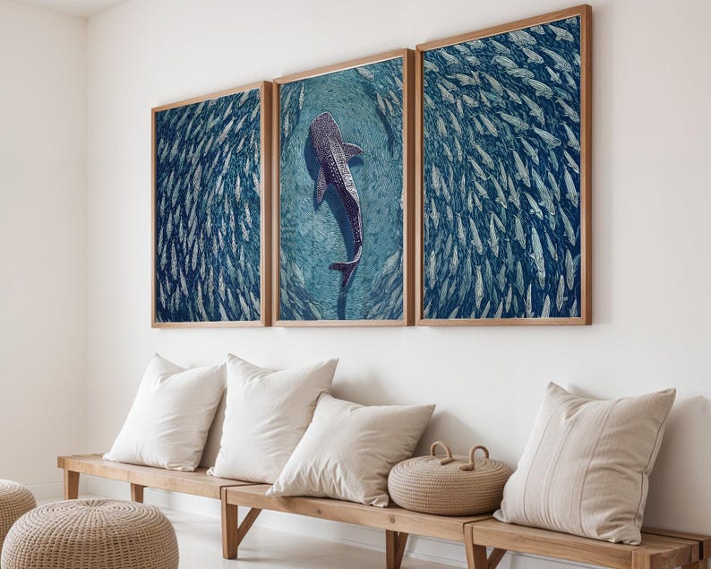 Pode incluir: Um conjunto de arte de parede em tr&iacute;ptico apresentando um grande tubar&atilde;o-baleia nadando em &aacute;guas azul-profundo, cercado por um cardume massivo de peixes menores. As tr&ecirc;s impress&otilde;es retangulares s&atilde;o emolduradas em madeira clara numa parede branca.