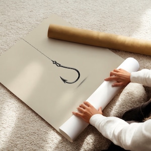 May include: A large, square, beige poster featuring a black line drawing of a single fishing hook attached to a thin fishing line. The poster is displayed flat, with a brown cardboard mailing tube resting nearby on the textured surface.
