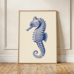 May include: A vertical rectangular wall art print featuring a detailed illustration of a seahorse in deep blue ink against a solid cream-coloured background. The seahorse is depicted in profile, showcasing its textured body, curved tail, and fins.