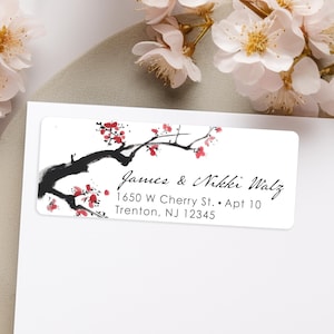 May include: A white return address label with a black and red cherry blossom branch design. The text reads "James & Nikki Walz, 1650 W Cherry St., Apt 10, Trenton, NJ 12345".