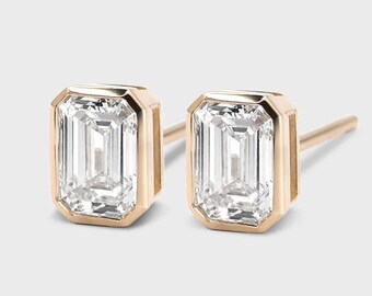 May include: A pair of gold earrings with emerald cut diamonds.