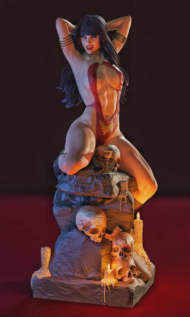 Peut inclure: Figurine d&eacute;taill&eacute;e d'une femme en body rouge avec un embl&egrave;me dor&eacute;, posant les bras au-dessus de la t&ecirc;te. Elle est assise sur une structure rocheuse avec des cr&acirc;nes et des bougies allum&eacute;es. L'ensemble est sombre avec un &eacute;clairage chaleureux.