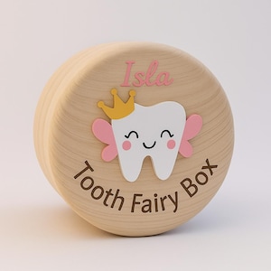 May include: A wooden tooth fairy box featuring a cartoon tooth with a gold crown, pink wings, and a smiling face. The name "Isla" is above the tooth, and "Tooth Fairy Box" is written around the base.