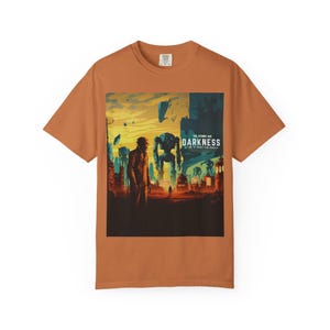 May include: Rust-colored t-shirt featuring a graphic from "The Atomic Age: Darkness". The artwork depicts a futuristic cityscape with a figure in a long coat, robots, and the text "Darkness: A Time of Horrifying Wonder".