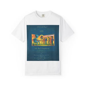 May include: White t-shirt featuring a graphic design with an alien seated in a chair, a group of people, and text. The design is in shades of blue, orange, yellow, and brown. The text includes the words "3115 Vol. 18CY", "Jol Kud Lhpinicos", and other text.