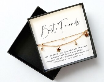 May include: A gold-colored, two-strand bracelet with star and crystal charms, presented in a black gift box. The card inside reads "Best Friends" and a sentimental message. A thoughtful gift.
