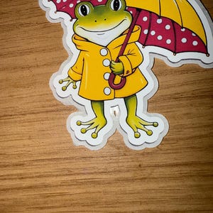 Süßer und Goofy Frosch Aufkleber - Regnerischer Tag Frosch im gelben Regenmantel - Wasserdichter Vinyl-Aufkleber für Laptops, Journals, Wasserflaschen und mehr