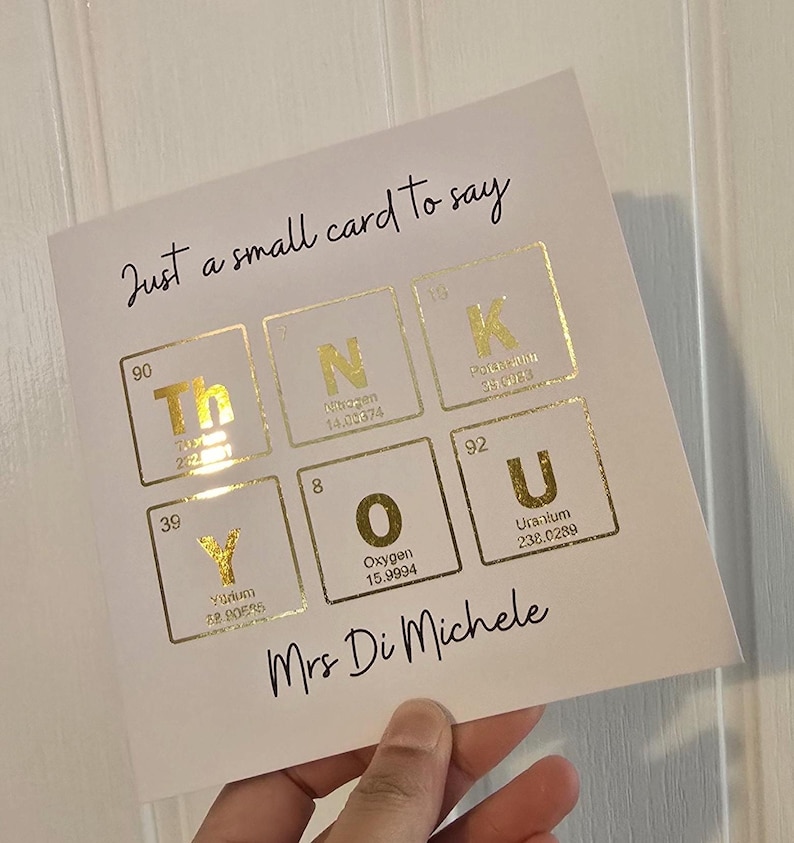 Peut inclure: Une carte de v&oelig;ux carr&eacute;e blanche avec le texte noir Just a small card to say et Mrs Di Michele. Au centre, le mot THANK YOU est &eacute;pel&eacute; &agrave; l'aide d'&eacute;l&eacute;ments du tableau p&eacute;riodique en feuille d'or, notamment le Thorium, l'Azote, le Potassium, l'Yttrium, l'Oxyg&egrave;ne et l'Uranium.
